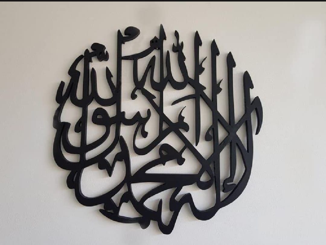 Round black laser-cut ms wall art featuring Arabic calligraphic text of the First Kalima (La ilaha illallah Muhammadur Rasulullah) with a smooth matte finish